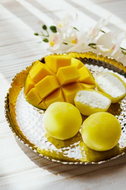 Ahşap arka planda mango meyveli Mochi tatlısı, yakın plan. Geleneksel Japon pirinç keki