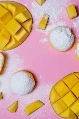 Tatlı Mochi, pembe arka planda mango meyvesi, yakın plan. Geleneksel Japon pirinç keki