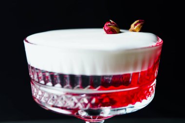 Alcoholic drink. A cocktail with elite alcohol on dark black background, close-up. Concept of  nightlife and exotic drinks.