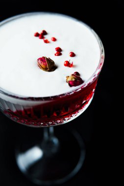 Alcoholic drink. A cocktail with elite alcohol on dark black background, close-up. Concept of  nightlife and exotic drinks.