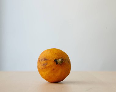 Ahşap bir masada çürümüş ya da kararmış bir limon..
