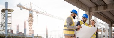 Mimarlar ve mühendisler inşaat alanındaki ilerlemeden çok memnun. Uzakta inşaat alanlarını ve vinçleri görebilirsiniz.