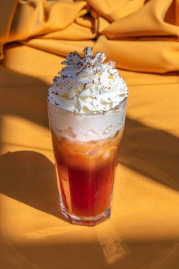 Sütlü buzlu kahve ve turuncu arka planda dondurma.