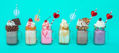Mason kavanozları dolusu lezzetli milkshake mavi izole arka planda.