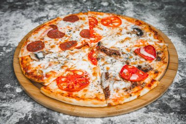 Soyut koyu arkaplanda buğday unuyla İtalyan pizzası dilimleri.