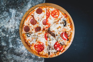 Soyut koyu arkaplanda buğday unuyla İtalyan pizzası dilimleri.