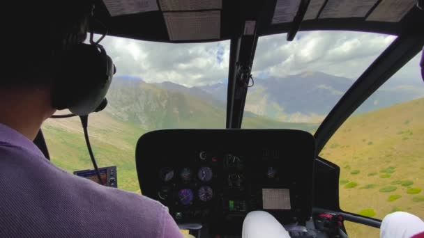 Helicopter interior during flight over mountains, focus on pilot or cockpit. — Stock Video