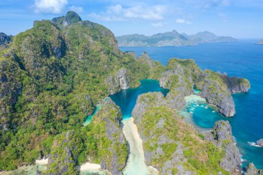 Gök mavisi deniz ve turist teknelerinin El Nido, Palawan, Filipinler 'deki güzel büyük ve küçük lagünlerin etrafını gösteren hava aracı görüntüsü..
