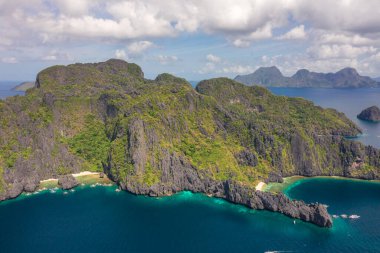 Tropikal mercan resifleri ve uzak kumlu Saklı Kumsal, El Nido, Palawan, Filipinler üzerindeki teknelerin insansız hava aracı görüntüsü.