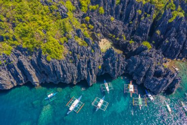 El Nido, Palawan, Filipinler 'de kayalık kıyıları ve gök mavisi tropikal denizi olan gizli bir göl. Mavi Göl 'de saklı bir cennet. Hava aracı görünümü.