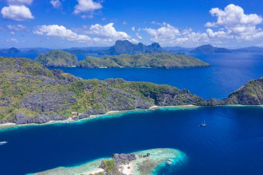 Güzel mercan kayalıkları, tekneler ve Matinloc Adası 'nda açık bir okyanus Bacuit Takımadası, El Nido, Palawan, Filipinler. Hava aracı görünümü.
