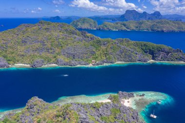 Güzel mercan kayalıkları, tekneler ve Matinloc Adası 'nda açık bir okyanus Bacuit Takımadası, El Nido, Palawan, Filipinler. Hava aracı görünümü.