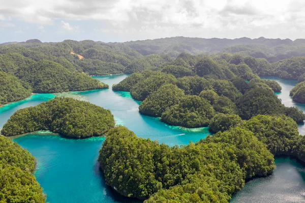 Teluk laut tropis dan laguna, pantai di Bucas Grande Island, Sohoton Cove. Filipina. Gunung lansekap tropis, awan dan gunung batu dengan hutan hujan. Air Azure dari laguna. Stok Gambar Bebas Royalti