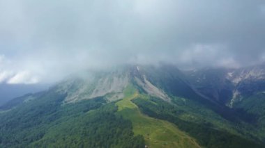 Karadağ 'ın Komovi kentindeki dağın tepesine giden hava aracı bulutlardan görülüyor.