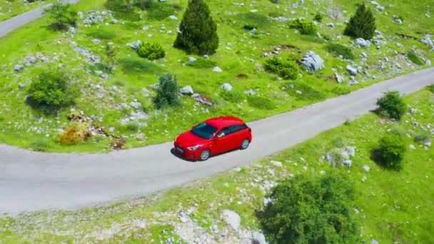 Flygfoto över väg med röd bil i vackra berg i Komovi. 15 juni 2021 - Montenegro. — Stockvideo