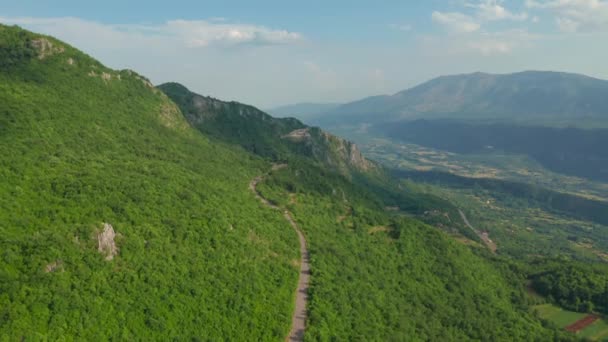 Вид с воздуха на зеленые горы с дорогой из близлежащего монастыря Острог, Черногория. — стоковое видео