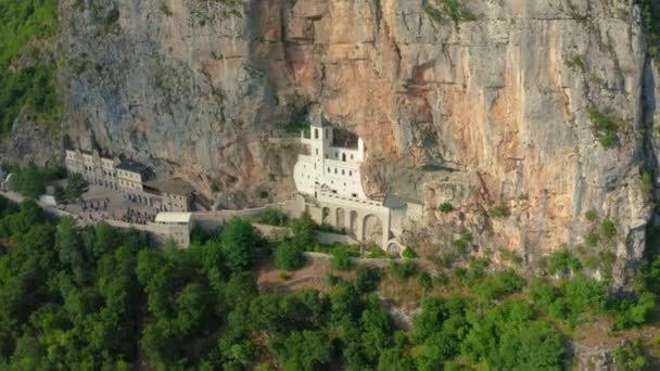 Vista aérea del monasterio de Ostrog en la montaña rocosa es el lugar de peregrinación más popular en Montenegro. — Vídeos de Stock