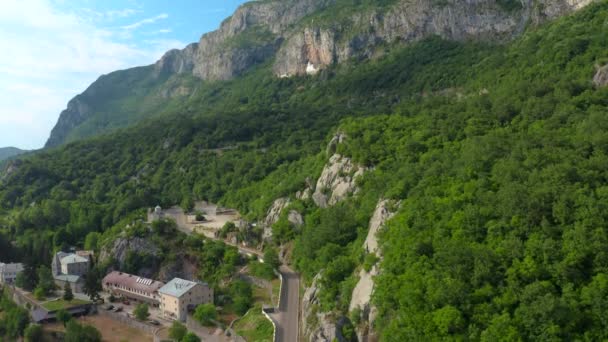 Letecký pohled na klášter Ostrog ve skalnatém montainu je nejpopulárnějším poutním místem v Černé Hoře. — Stock video