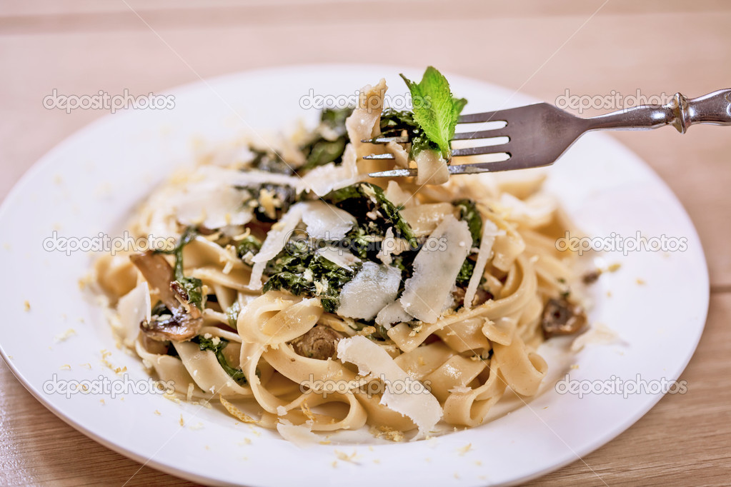 Delicious vegetarian dish of pasta and parsley on wooden table