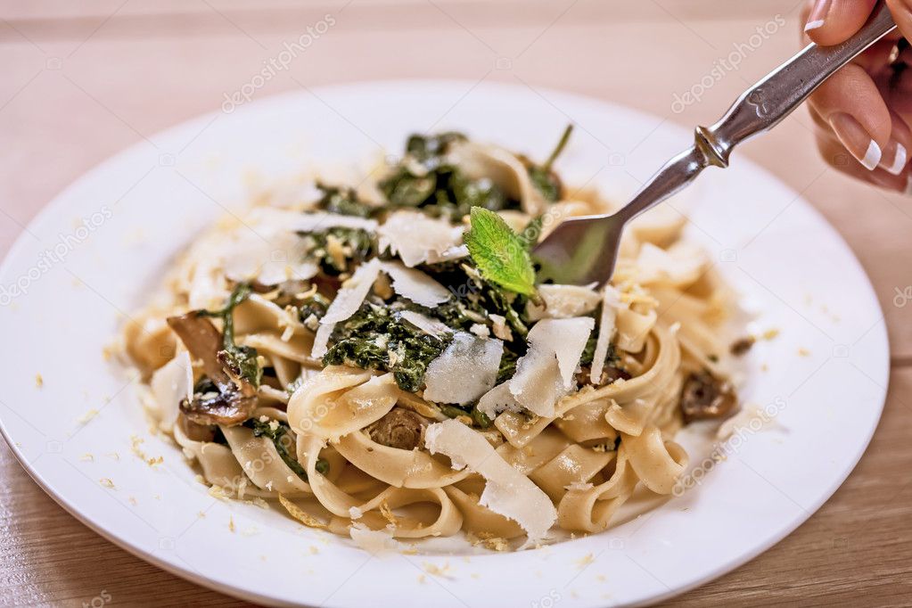 Delicious vegetarian dish of pasta and parsley on wooden table