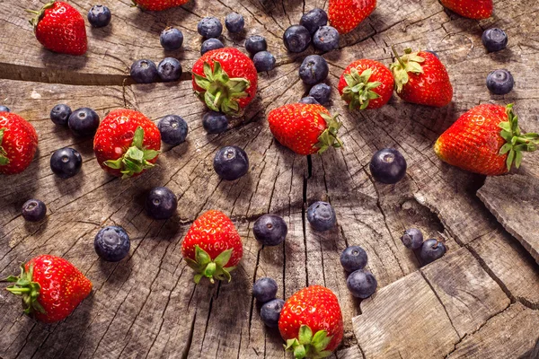 Arándanos y fresas sobre madera en la naturaleza — Foto de Stock