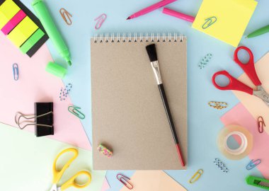 Renkli arkaplanda farklı kırtasiye malzemesi, metin için boş alan var. Okula geri dön.