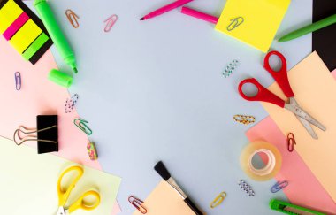 Renkli arkaplanda farklı kırtasiye malzemesi, metin için boş alan var. Okula dönelim. Metin için boşluk