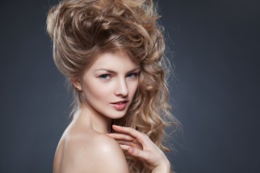 Genç model gri backg üzerinde sarışın kıvırcık saçlı güzellik atış