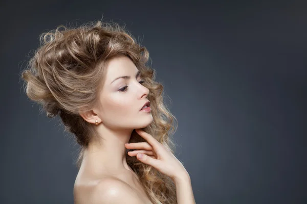Belleza de modelo femenino con el pelo rubio rizado sobre la espalda gris —  Fotos de Stock