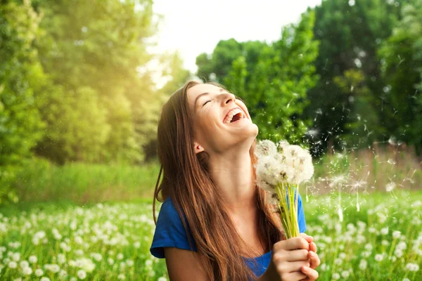 Ritratto di ragazza ridente con denti di leone al parco — Foto Stock