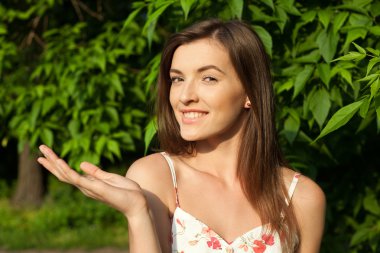 elini tutarak, bir produ gösterilen güzel kadın modeli portresi