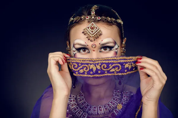 Portrait of an oriental woman in a traditional costume half of f — Stock Photo, Image