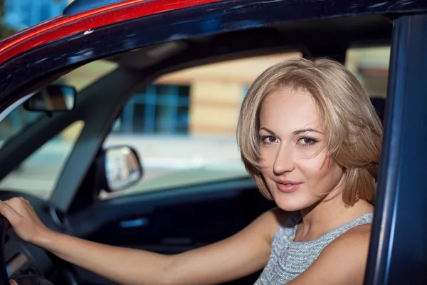Portrait of young pretty blonde woman in the red car — Stock Photo, Image