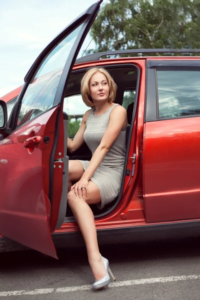 Luxurious woman in a short shiny dress and shoes coming out of t — Stock Photo, Image