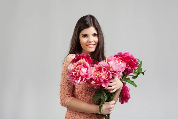 Mujer sonriendo y sosteniendo flores — Foto de Stock