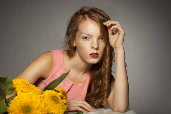 Sarı çiçekleri olan Kızıl saçlı kadın — Stok fotoğraf