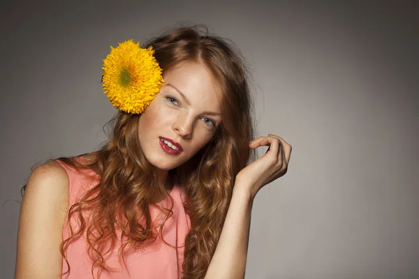 Mujer joven pelirroja con flores amarillas —  Fotos de Stock