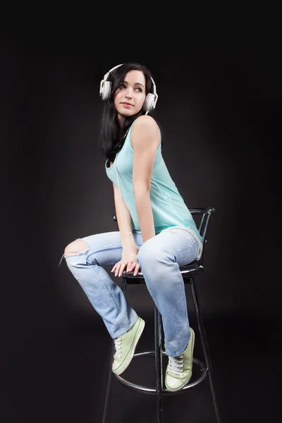 Kvinna lyssnar musik på stolen — Stockfoto