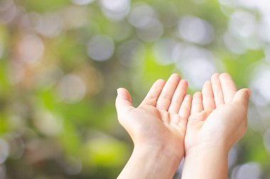 iki el açık yakın plan yeşil bulanık bokeh arkaplan üzerinde boş alan alma veya umut yardıma ihtiyacı