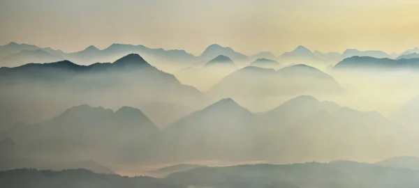 高地での夜明け前の時間 霧の中の山のシルエット — ストック写真