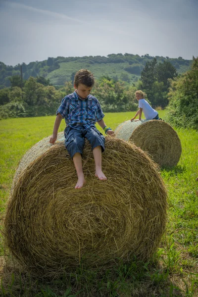 Boys on round hay bales — Stock Photo, Image