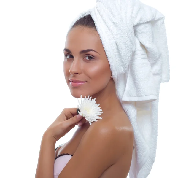 Retrato de uma bela jovem com uma flor na mão e uma toalha na cabeça — Fotografia de Stock