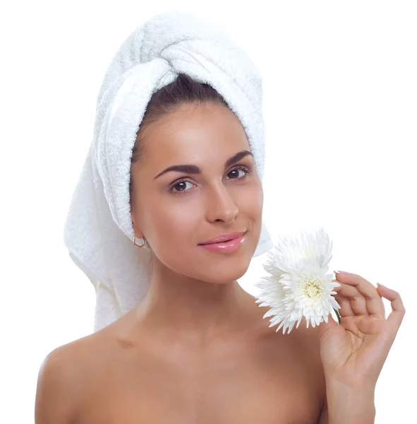 Belle jeune femme avec une serviette sur la tête et une fleur dans la main — Photo