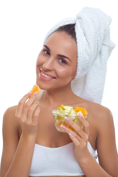 Retrato de una hermosa joven con una toalla en la cabeza y un plato de ensalada de frutas en la mano — Foto de Stock