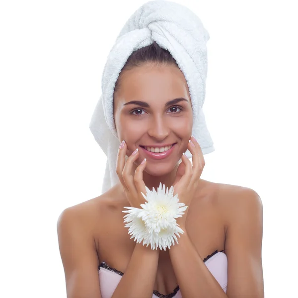 Retrato de una hermosa joven con una toalla en la cabeza y sosteniendo flores — Foto de Stock