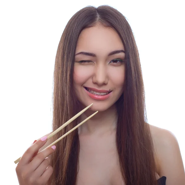 Retrato de una hermosa joven asiática con el pelo largo y palillos para sushi en las manos —  Fotos de Stock