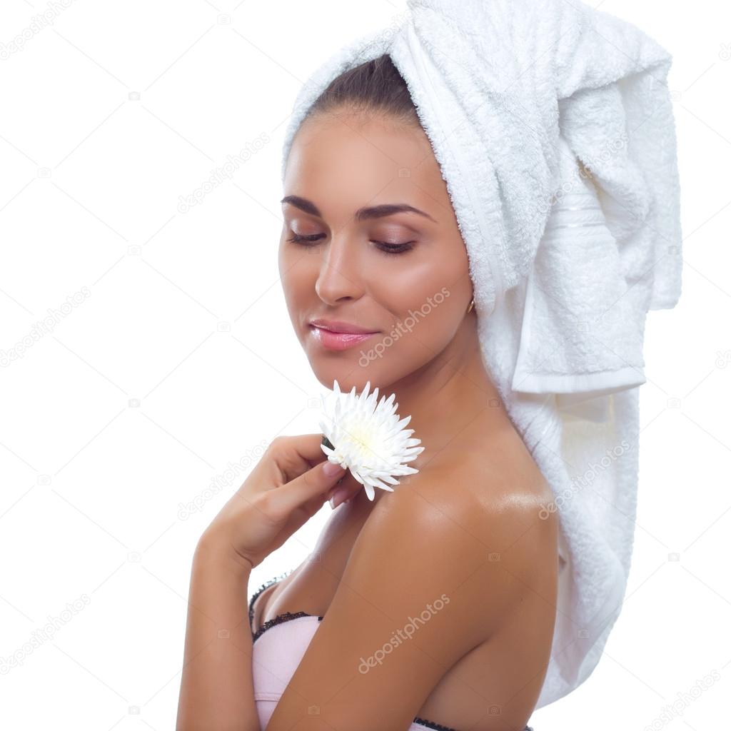 beautiful young smiling woman with a towel on his head and a flower in her hand
