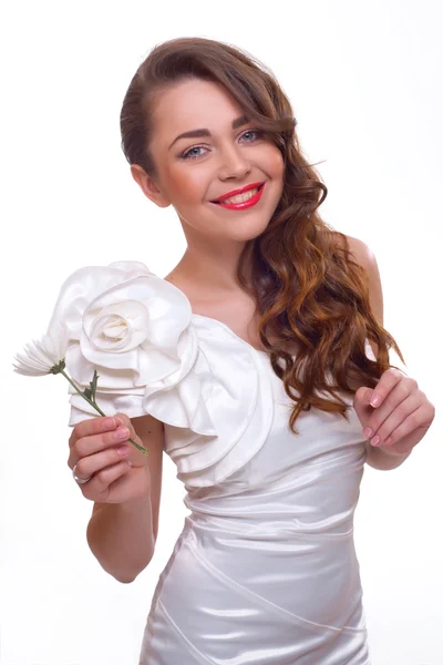 Retrato de una hermosa joven con el pelo largo y rizado y una flor en la mano — Foto de Stock