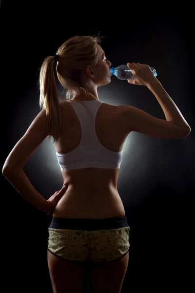 Sportovní krásná mladá blondýnka pitnou vodu z láhve — Stock fotografie