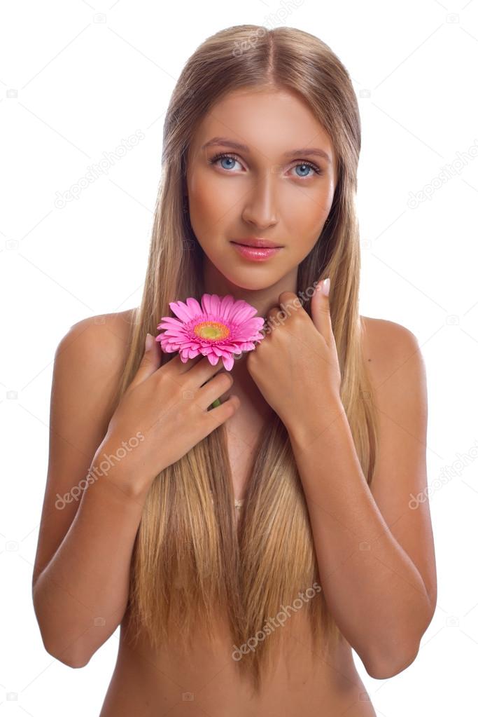Portrait of a beautiful young woman with long hair and flower in hand